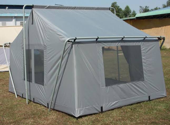 Large emergency relief tents deployed in Uganda – white heavy-duty shelters arranged in a camp layout for refugee accommodation and disaster response operations.