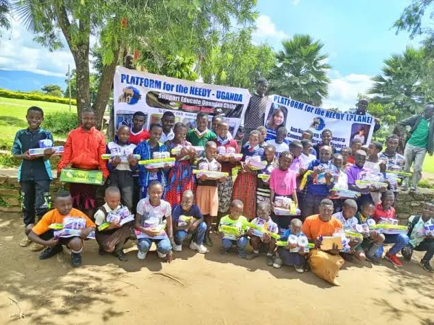 Assorted NGO supply kits – medical boxes, hygiene packs, shelter tarpaulins, and water purification tablets arranged on a pallet, ready for distribution in Uganda.